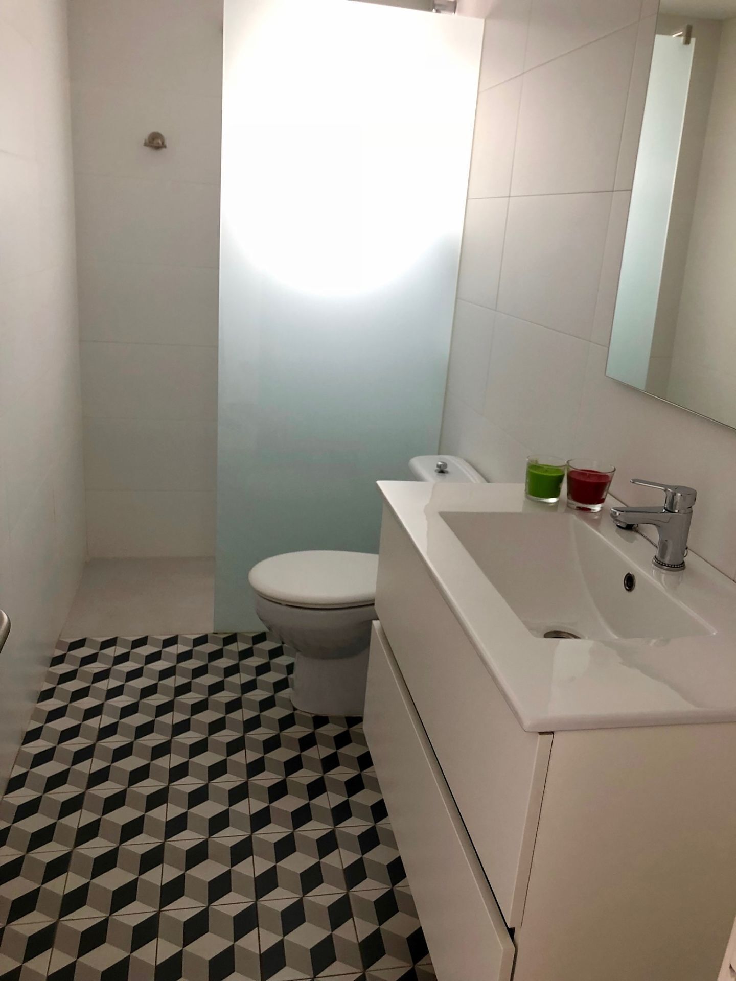 Een badkamer met een toilet, een wastafel en een spiegel.
