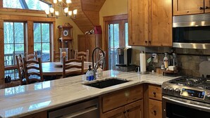Una cocina con armarios de madera, estufa de acero inoxidable y una isla grande con fregadero.