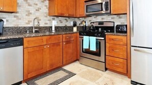 A kitchen with wooden cabinets, a stainless steel microwave, a stove, and a dishwasher. - New Carlsbad Beach house - Blocks from beach with rare  cental Air Conditioning (Carlsbad)