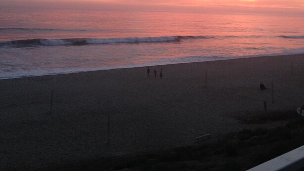 A beach with a sunset sky, waves, and a few people walking. - New Carlsbad Beach house - Blocks from beach with rare  cental Air Conditioning (Carlsbad)