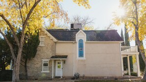 A two-story building with a stone facade, a central entrance with a door, and a small porch with a railing. - Perfect for Families (St George)