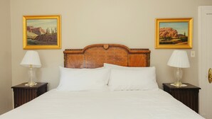 A bed with a wooden headboard, two nightstands with lamps, and two framed pictures on the wall. - Perfect for Families (St George)