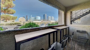 A balcony with a view of a city skyline, a table, and two chairs. - Fantastic Strip view walking distance 2br2b condo (Las Vegas)