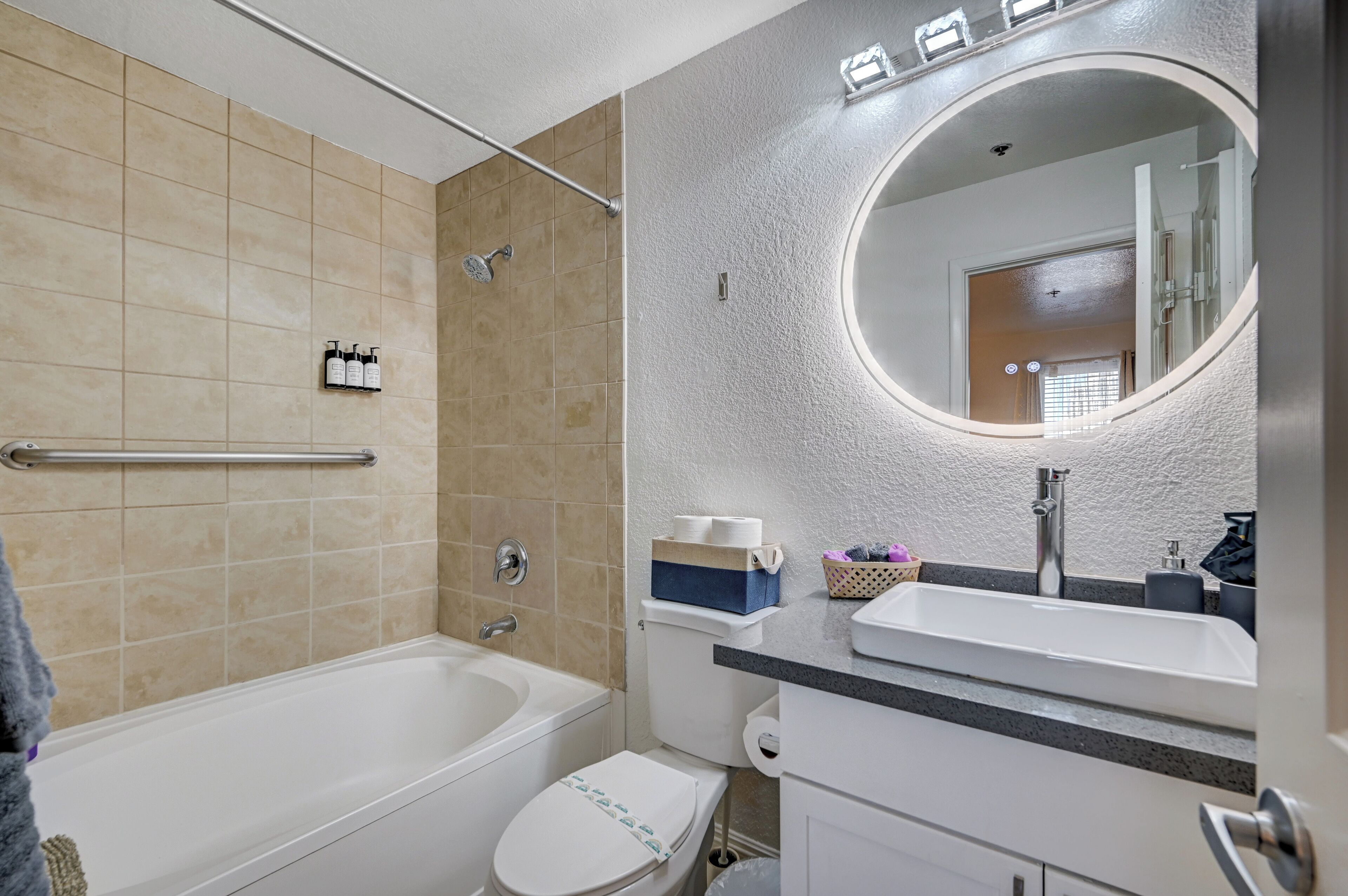 A modern bathroom with a bathtub, toilet, and sink.
