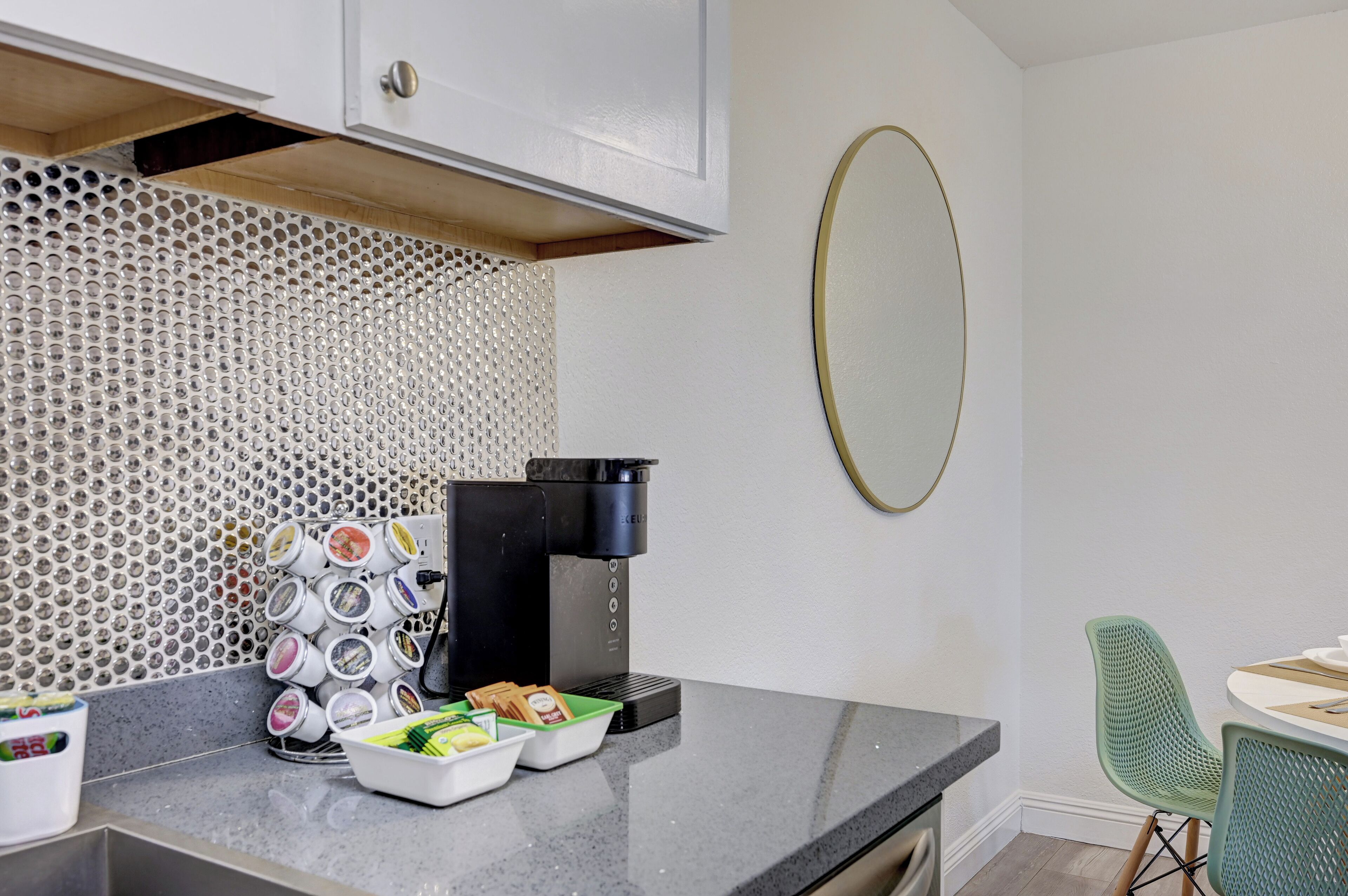 A kitchen with a coffee maker, a microwave, and a food storage unit.