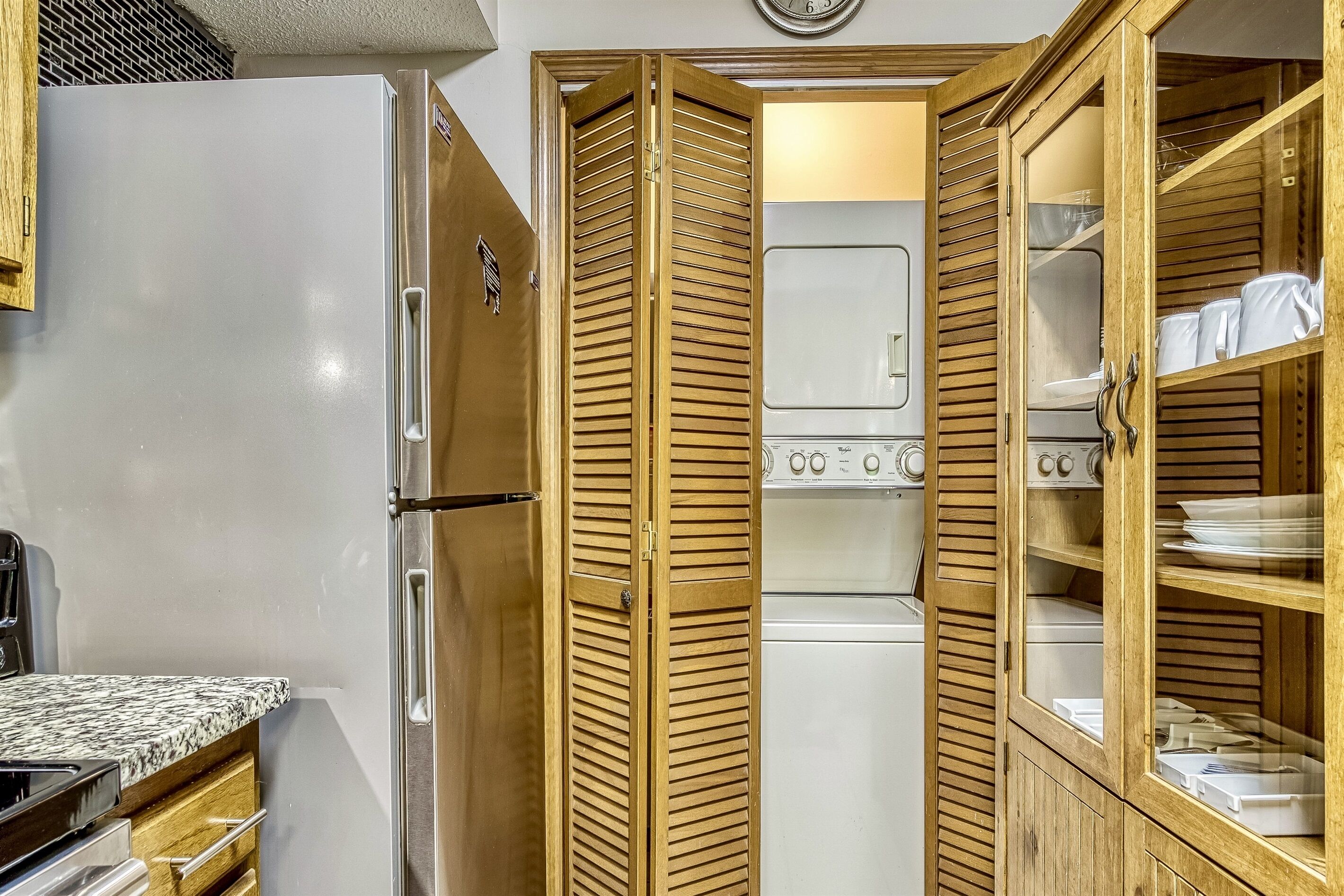 Eine kleine Küche mit Kühlschrank, Backofen und Holzausstattung.