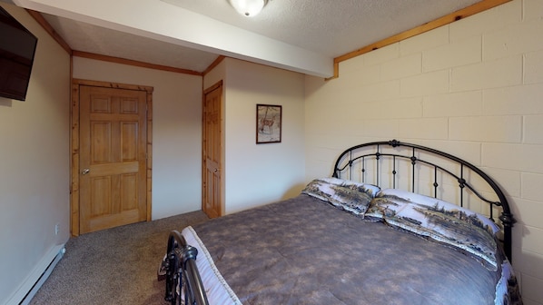 Ein Schlafzimmer mit einem Bett, einer Holztür und einem Bild an der Wand.