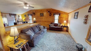 A cozy living room with a sofa, a coffee table, and a fireplace.