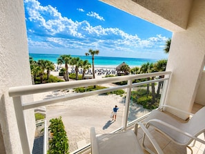A balcony with a view of a beach, palm trees, and a clear sky. - 2/2 Beachfront, VIEWS, Pool, Private Beach Access (Longboat Key)