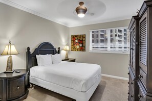Camera da letto con un letto, due comodini con lampade, una ventola a soffitto, una finestra con tende e un comò.