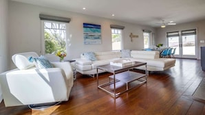 A spacious living room with a white sofa set, a coffee table, and a dining area with blue chairs. - Village Life, walk to the village of La Jolla (La Jolla)
