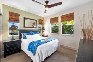 A bedroom with a bed, nightstands, a ceiling fan, and windows with bamboo blinds. - Affordable Luxury Oceanview 3/2 @ Hali'i Kai 8H-Family Friendly!  (Waikoloa Resort)