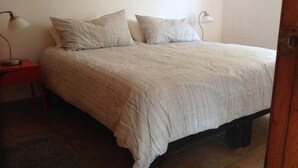 Une chambre à coucher avec un lit, deux tables de chevet et une commode.