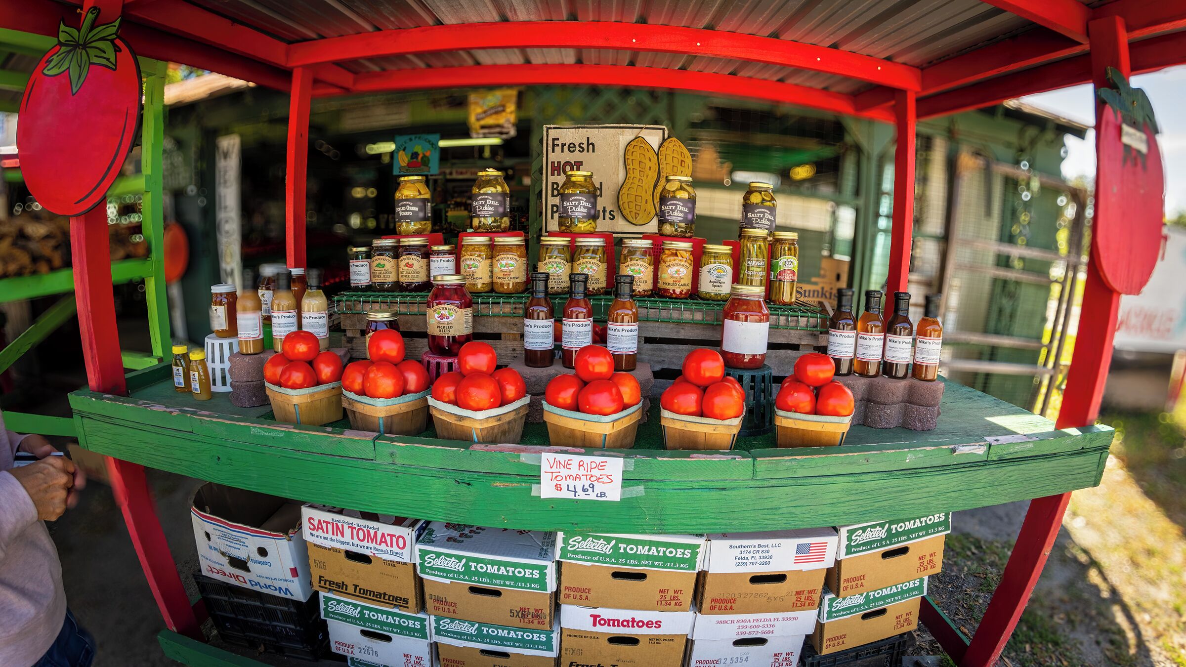 Un étal installé au bord de la route où l’on vend des tomates fraîches, des cornichons et diverses sauces.