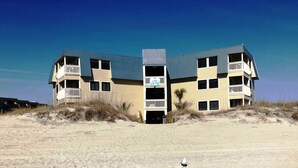 A vacation condo named "The Black Pearl" at A Place at the Beach IV, featuring a multi-story structure with balconies and a beachside location.