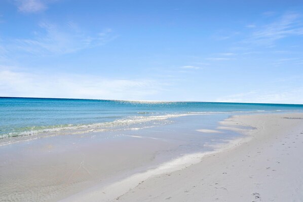 Una playa con agua cristalina y una orilla arenosa.