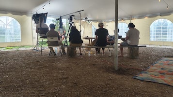 A tented area with a dirt floor, large windows, and a camera setup.