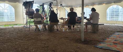 A tented area with a dirt floor, large windows, and a camera setup.