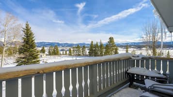 A balcony with a view of snow-covered landscape and mountains.