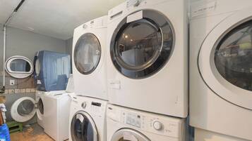 A laundry room with multiple stacked washing machines.