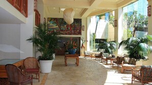 A spacious lobby with a pool table, comfortable seating, and large potted plants.