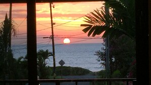 A sunset view through a window with a car parked outside. - Maui Special!! 2BDRM/2BA Ocean View and Convenient Location (Kihei)