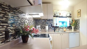 A modern kitchen with a tiled backsplash, a sink, a coffee maker, and a potted plant. - Maui Special!! 2BDRM/2BA Ocean View and Convenient Location (Kihei)