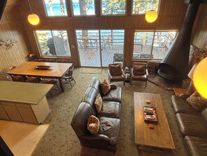 A cozy interior with a wooden dining table, leather sofa, and a fireplace.
