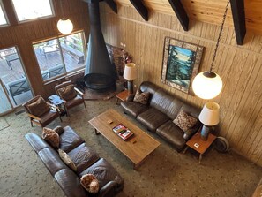 A cozy living room with leather sofas, a coffee table, and a fireplace.
