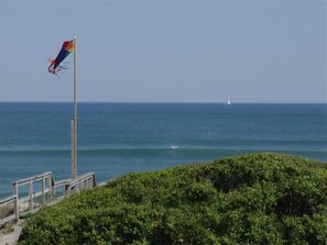 Enjoy breathtaking ocean views from this serene coastal retreat, where a sailboat glides across the horizon and a kite soars overhead.