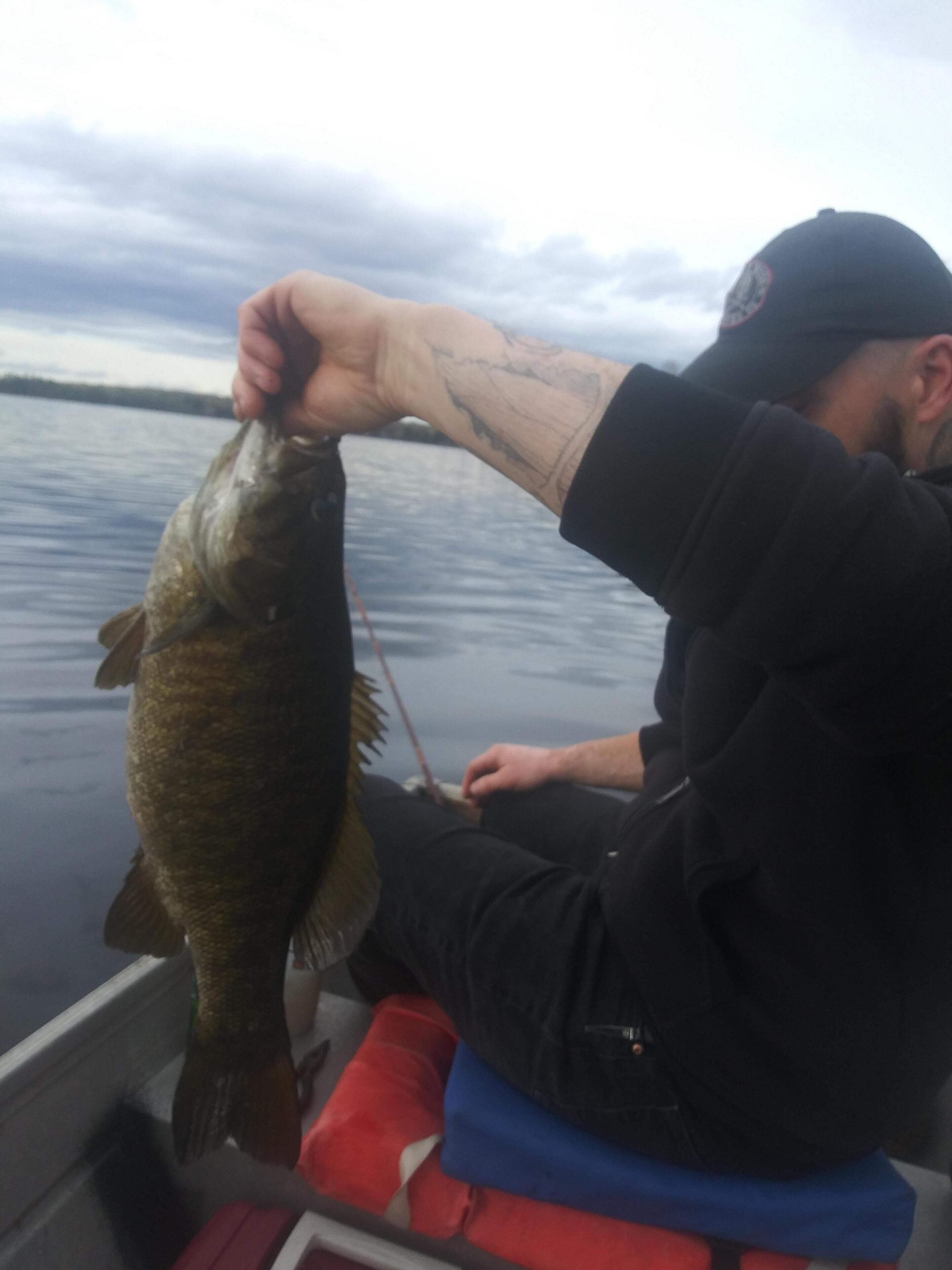 Une personne tenant un poisson sur un bateau.