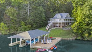 Une maison au bord du lac, dotée d’un quai, d’un espace salon abrité et d’une rampe pour bateaux.