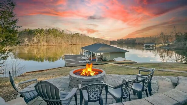 Une terrasse au bord du lac, avec un foyer, des sièges d’extérieur et un belvédère.