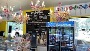 A colorful ice cream shop with a menu board, a cash register, and a variety of ice cream flavors. - Historic Gated Estate, Pool, Cabana, 2 Kitchens, Lush, Kayaks, Walk 2 Frio! (Concan)