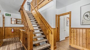 A wooden staircase with carpeted steps leading to a landing.