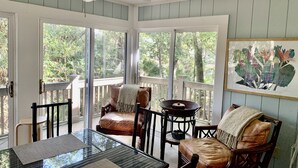 A sunlit room with a glass table, leather chairs, and a ceiling fan. - Favorite cottage - large kitchen and renovated bathrooms, sunroom (Kiawah Island)