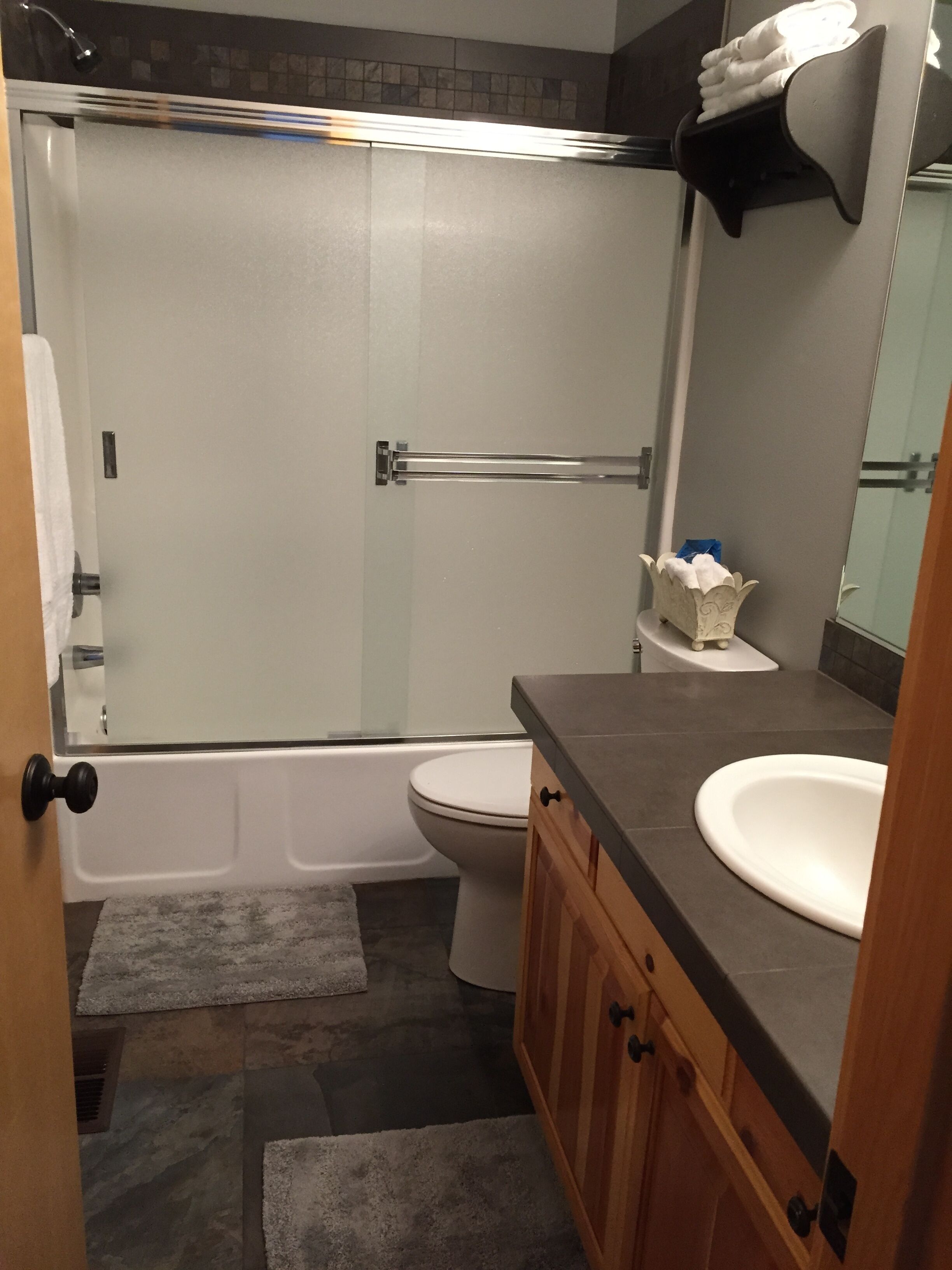 A bathroom with a shower, toilet, and sink.