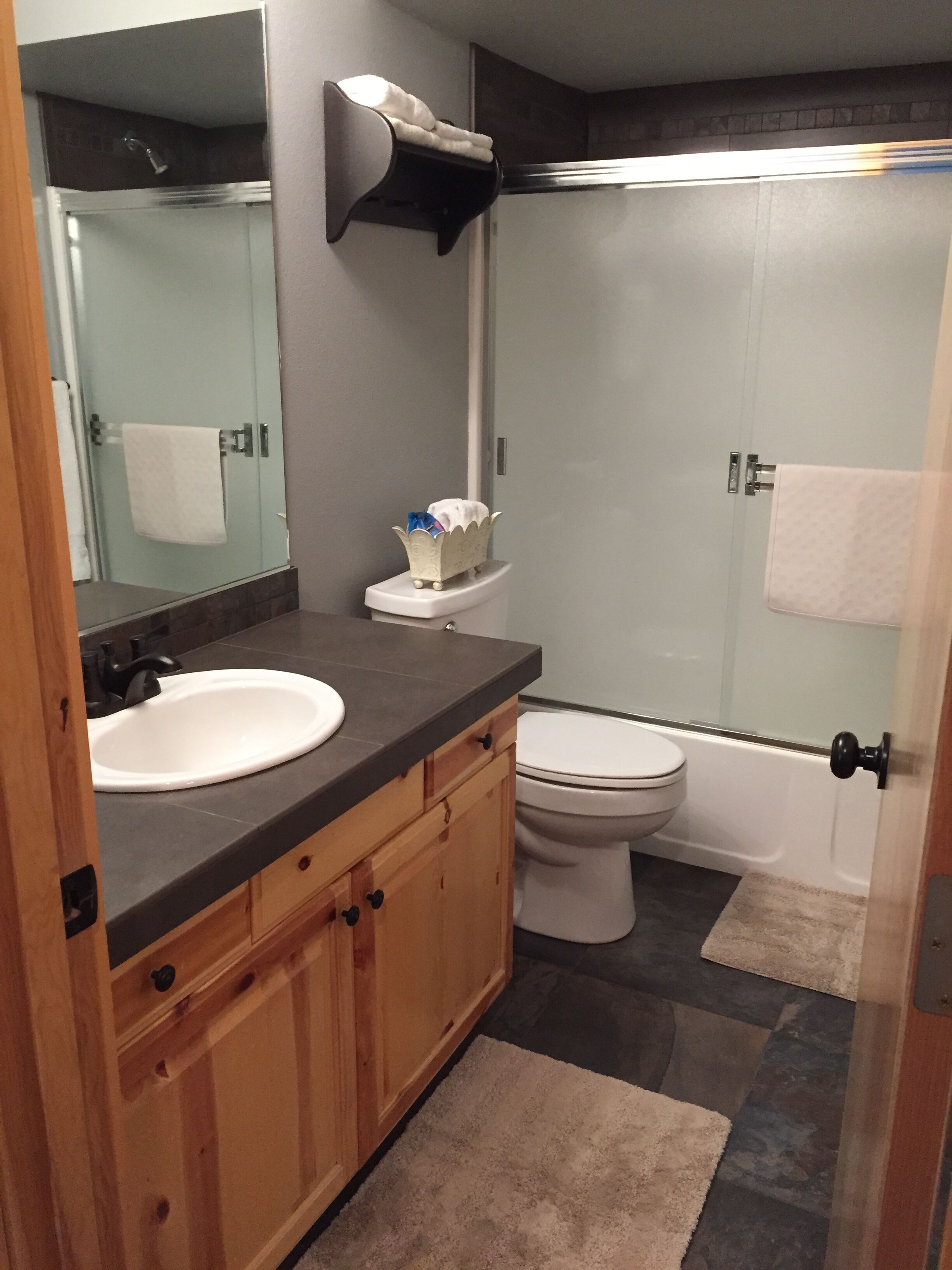A modern bathroom with a sink, toilet, and shower.