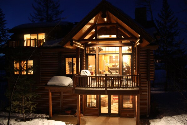 Enjoy the serene atmosphere from the spacious porch and balcony of this cozy cabin, offering breathtaking views of the surrounding winter landscape.