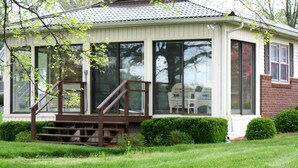A covered porch with a wooden staircase leading to a seating area.
