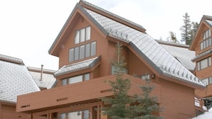 Ein hölzernes Gebäude mit einem Schild, auf dem „Arrowhead Chalets“ steht.