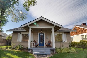 A two-story house with a blue front door, two wooden chairs on the porch, and a number 735 on the wall. - Hygge Harmony- Salt Hot Tub, 2 Fireplaces, 100+mbps Wifi, AC, Walk to Galveston! (Bend)