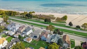 Een woongebied aan de kust met huizen, een strand en een helder uitzicht op de oceaan.