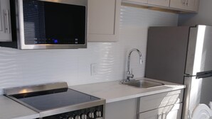 A modern kitchen with stainless steel appliances, a built-in oven, and a microwave.