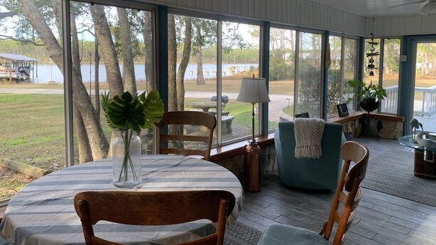 Un espace extérieur abrité, aménagé avec une table, des chaises et un pot de fleurs.
