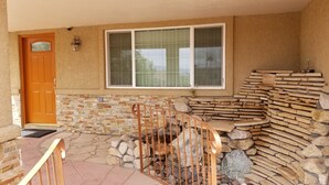 A stone-walled porch with a wooden door and a window.