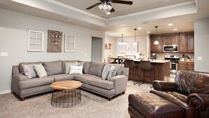 A spacious living room with a sectional sofa, a leather armchair, and a wooden coffee table. - 5 ⭐️ Clean & Quiet Barstow Retreat (Amarillo)