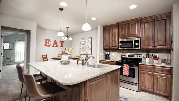 A modern kitchen with a large island, wooden cabinets, stainless steel appliances, and pendant lighting. - 5 ⭐️ Clean & Quiet Barstow Retreat (Amarillo)