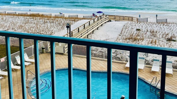 A beachside pool area with a wooden deck, lounge chairs, and a view of the ocean. - Fall Steal! 129/nt base! Gulf front, Pool,Huge Balcony,Beach Supplies,VIEW! (Gulf Shores)