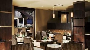 A dining area with wicker chairs, a long table, and hanging pendant lights. - A View from the Top!  Las Palomas Penthouse Level Beachfront Luxury Condo!!! (Puerto Penasco)